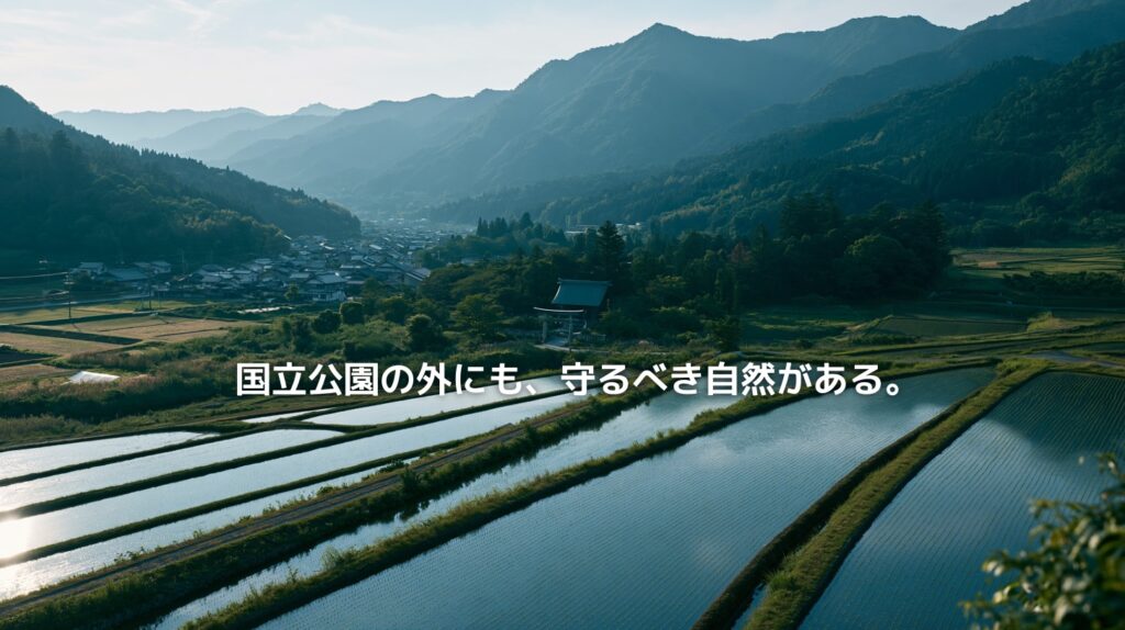 水田と里山、鎮守の森が広がる山あいの集落風景