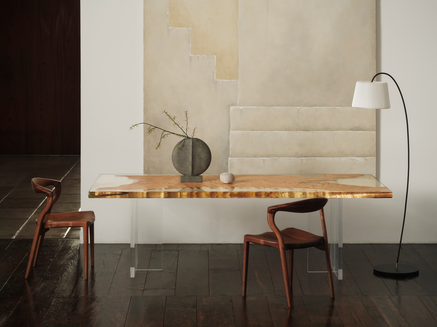 無垢の木のテーブルと二脚の椅子が並ぶ、静かな空間。柔らかな光と陰影が、千年家具の余白の美を際立たせている。