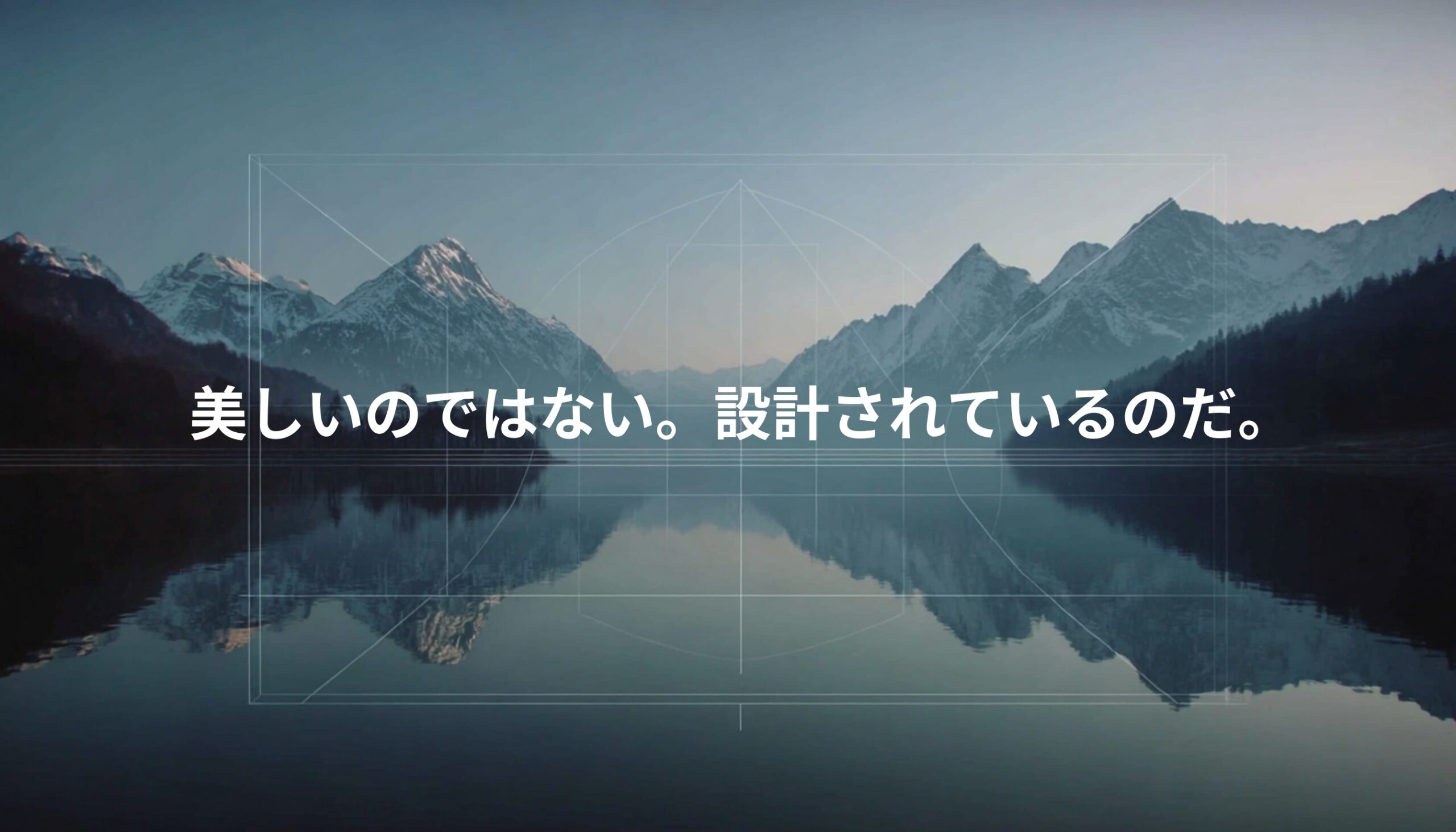 スイス・アルプスの湖面に山が対称的に映る風景。「美しいのではない。設計されているのだ。」というテキストが重なる構造美を象徴するビジュアル。
