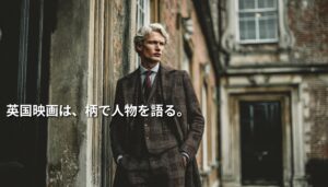 クラシックな英国建築の外壁沿いに、チェック柄のスーツとコートを着た男性が立つ。画像左側には「英国映画は、柄で人物を語る。」という白文字が配置されたアイキャッチ画像。