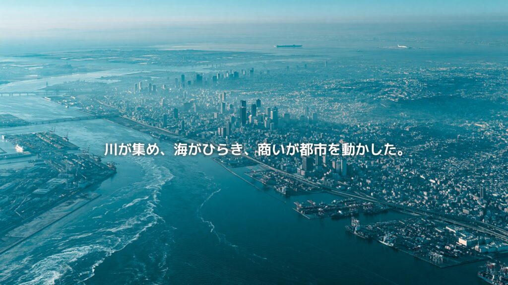 大阪湾と淀川周辺の水辺、大阪市の高密度な都市景観、湾岸の港湾エリアを俯瞰した風景。川と海と商いが大阪の都市圏を形づくってきたことを表現したアイキャッチ画像。