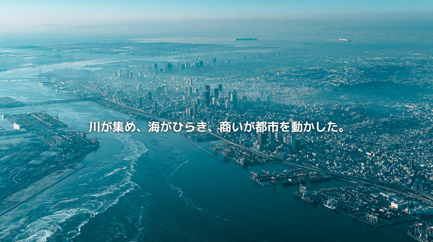 大阪湾と淀川周辺の水辺、大阪市の高密度な都市景観、湾岸の港湾エリアを俯瞰した風景。川と海と商いが大阪の都市圏を形づくってきたことを表現したアイキャッチ画像。