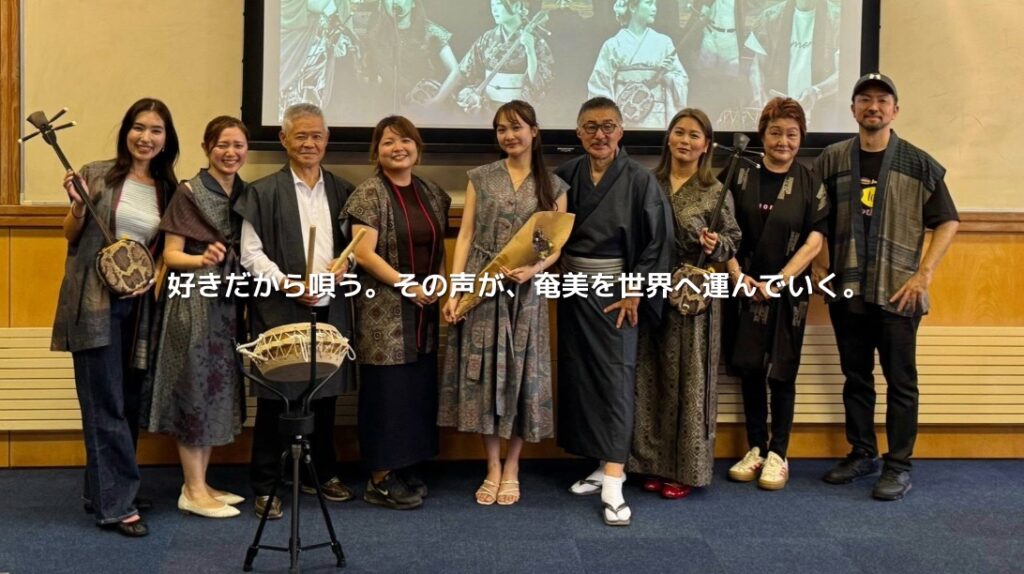 成瀬茉倫さん、田向美春さんら奄美の島唄奏者の集合写真。「好きだから唄う。その声が、奄美を世界へ運んでいく。」の文字