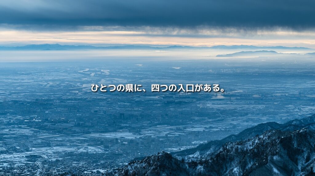 雪山から新潟の平野と市街地、日本海、佐渡を望む俯瞰風景。「ひとつの県に、四つの入口がある。」の文字