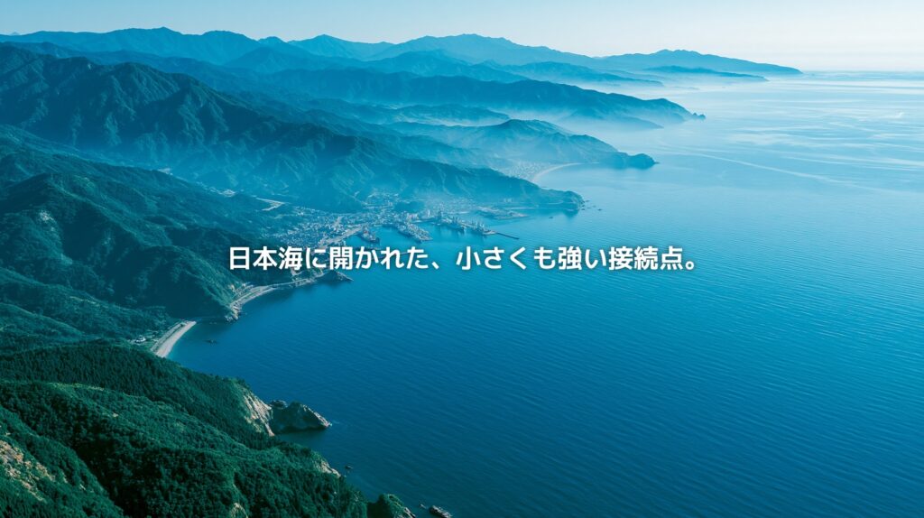 日本海に面した福井県の海岸線、若狭湾を思わせる入り組んだ湾、山々に囲まれた港町を俯瞰した風景。福井県が日本海に開かれた小さくも強い接続点であることを表現したアイキャッチ画像。