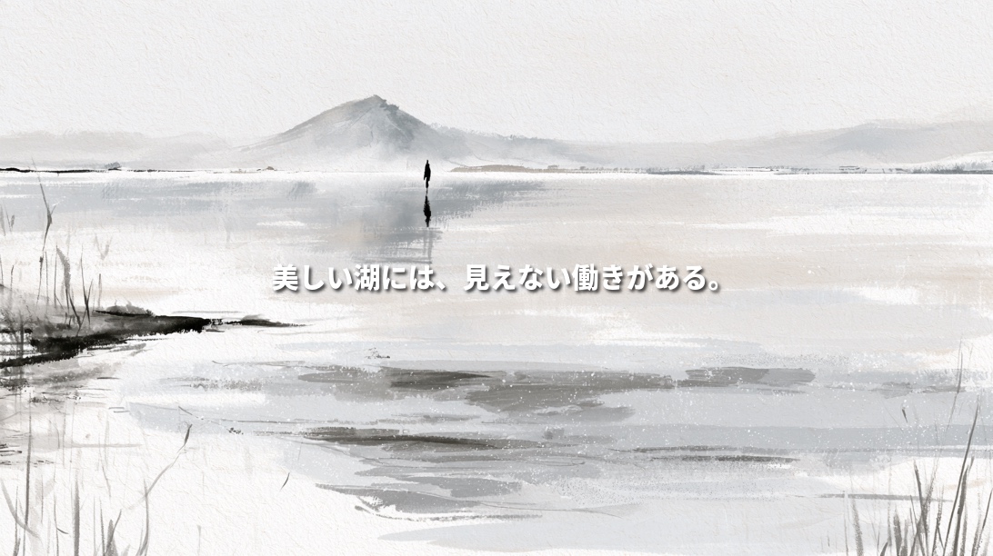 Monochrome ink-wash illustration of Lake Inawashiro, with Mount Bandai in the distance, reeds along the shore and reflections on calm water. Japanese text reads “A beautiful lake is sustained by unseen processes.”